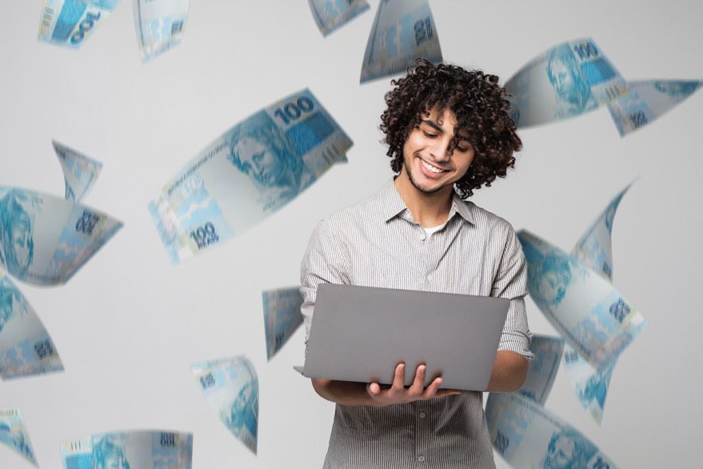 Pessoa sorrindo enquanto usa um laptop, com notas de dinheiro ao fundo, simbolizando sucesso financeiro.