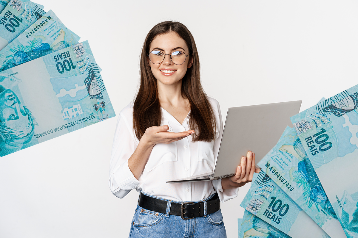 Mulher segurando um laptop e mostrando notas de 100 reais, simbolizando o uso consciente de crédito.