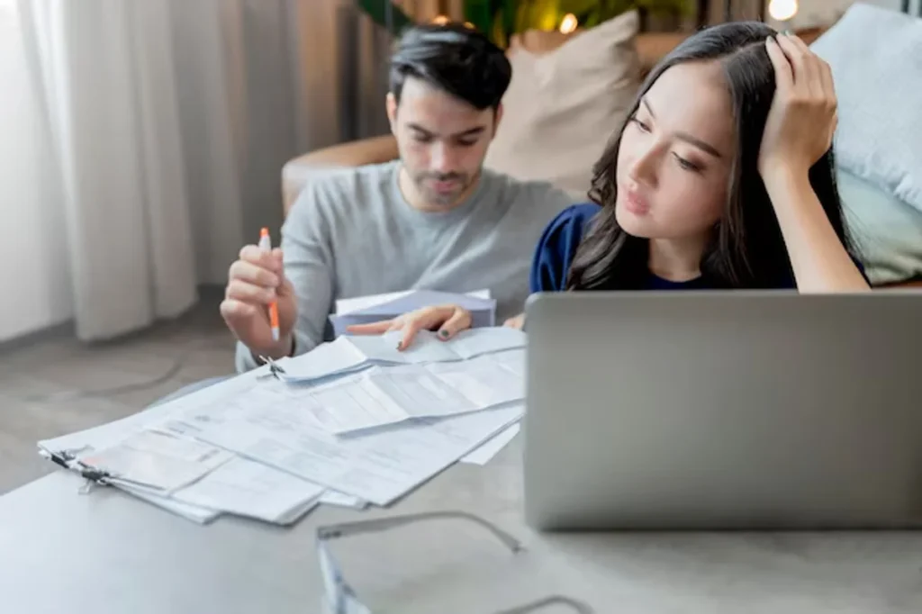 Casal analisando documentos financeiros enquanto lidam com questões de crédito e empréstimos.