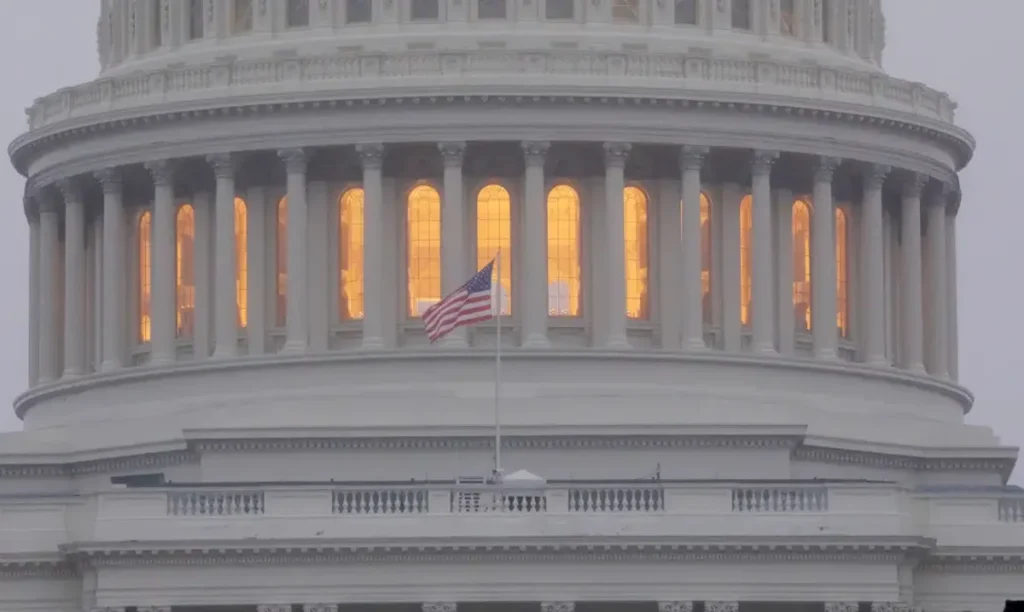 Vista detalhada da Cúpula do Capitólio dos Estados Unidos com a bandeira americana em primeiro plano, simbolizando o impacto da Lei Magnitsky.