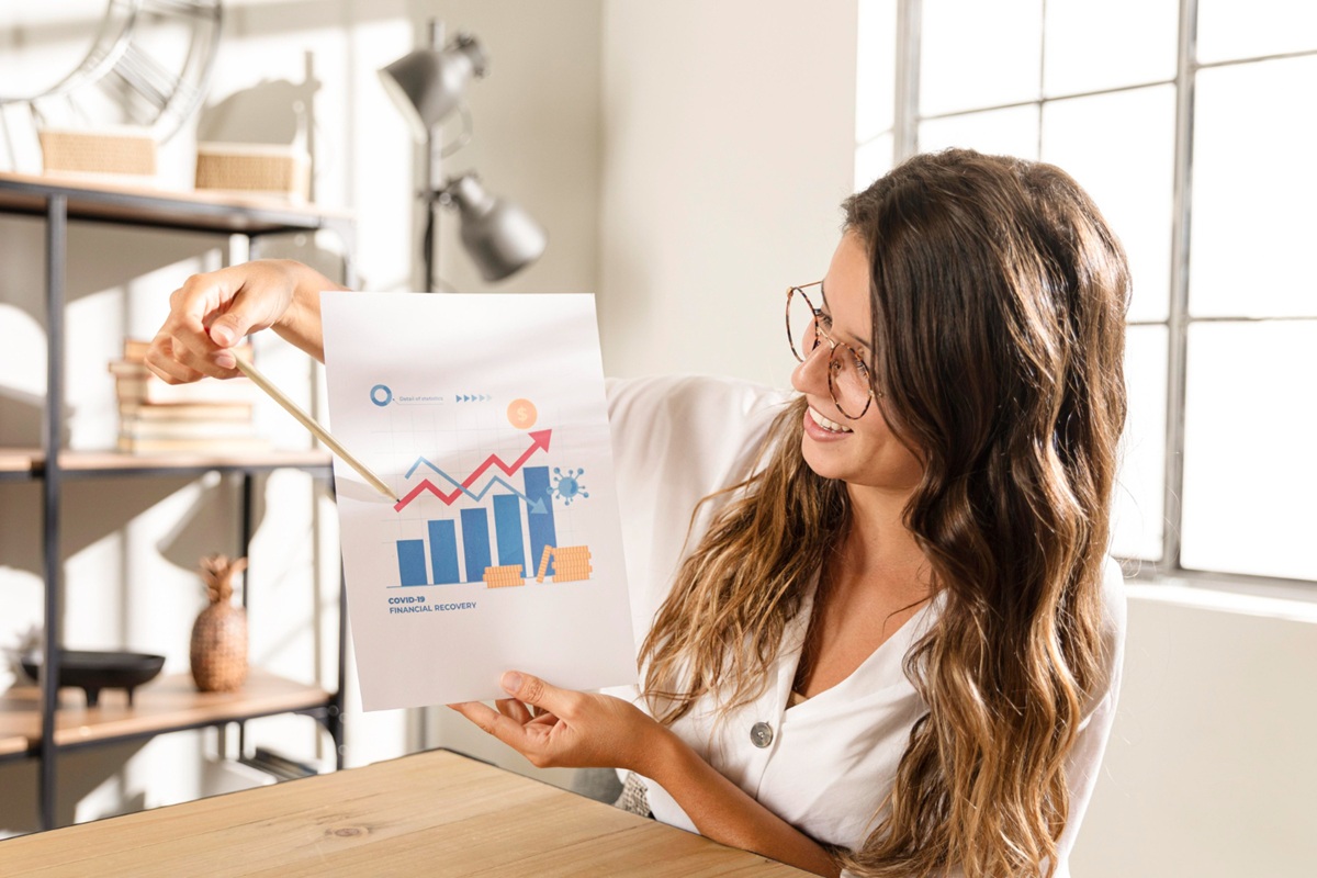 Profissional analisando relatório de recuperação financeira com gráficos de crescimento e indicadores econômicos positivos