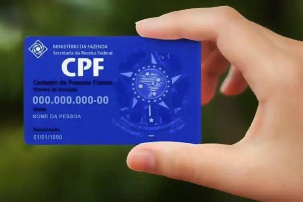 Pessoa segurando cartão azul representando o CPF.