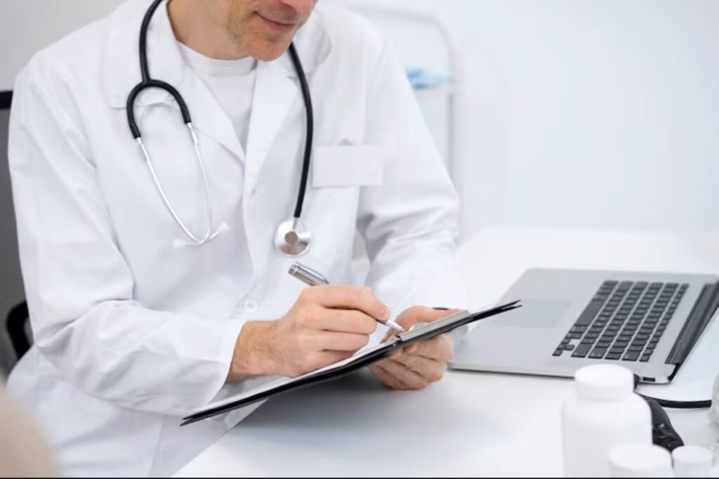 Médico escrevendo em uma prancheta, em um escritório, com plano de saúde e vale-refeição em pauta.