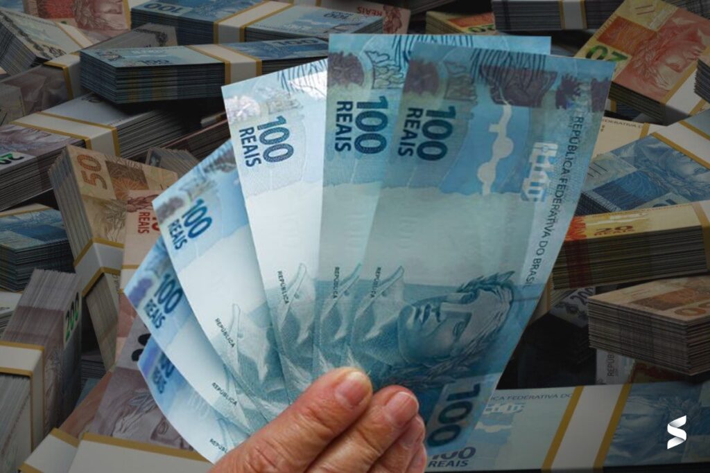 Notas de 100 reais ao lado de várias outras cédulas.