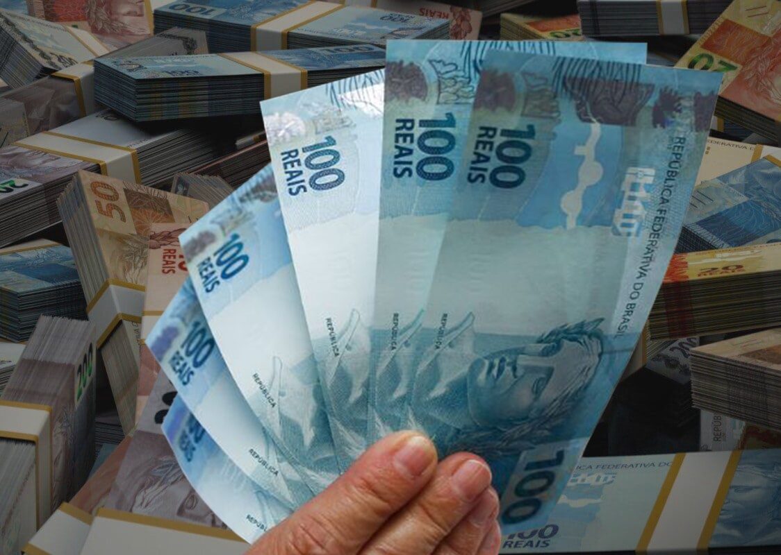 Notas de 100 reais ao lado de várias outras cdulas.