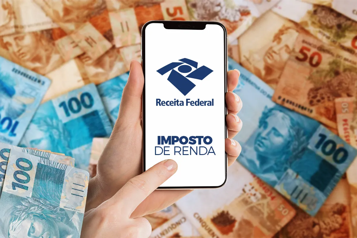 Mão segurando um celular com o aplicativo da Receita Federal e o texto "Imposto de Renda" na tela, cercado por notas de R$ 100 e R$ 50, simbolizando a modernização da declaração.