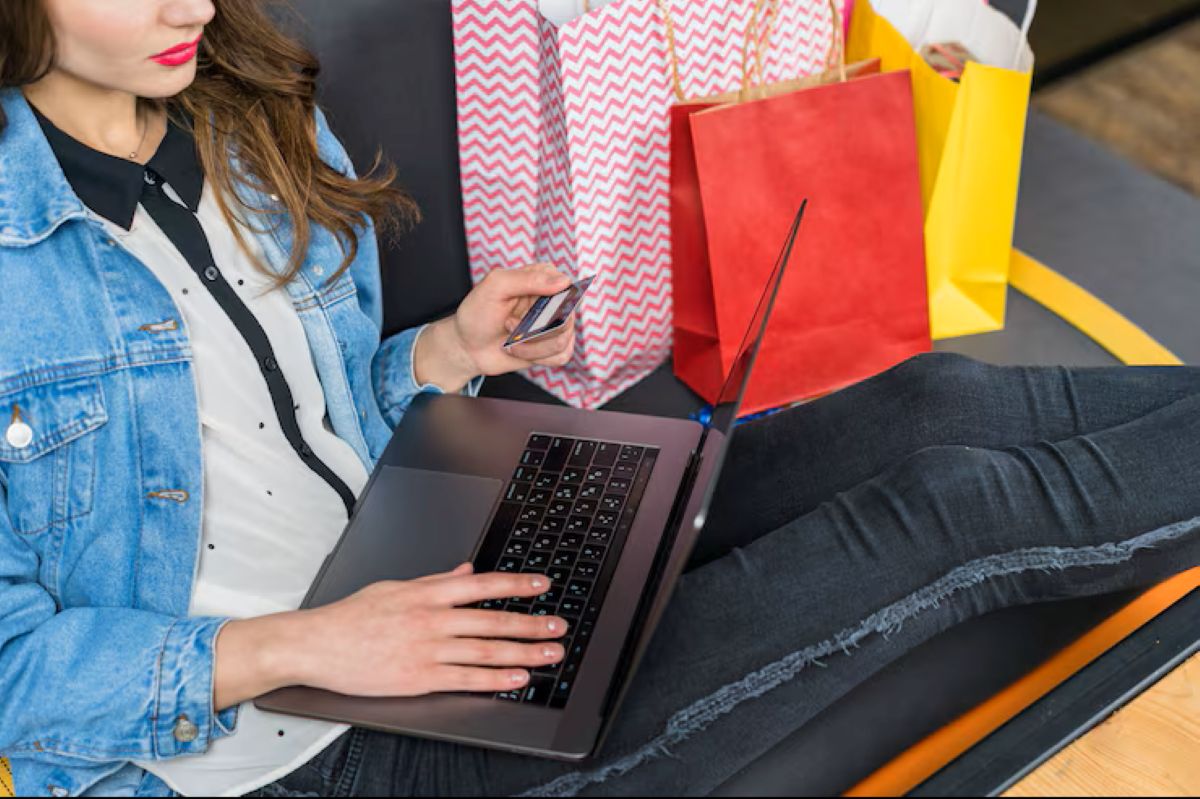 Mulher usando notebook e celular para comparar preços e identificar ofertas reais na Black Friday 2025