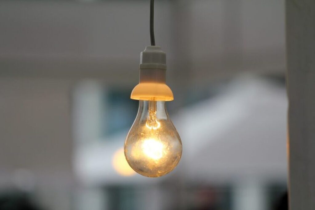 Lâmpada acesa em ambiente interno, simbolizando economia de energia e o benefício na conta de luz.