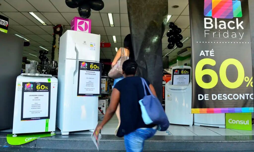 Clientes entram em loja com banners Black Friday e promoções de até 60% em eletrodomésticos