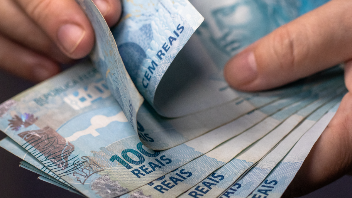 Contagem de notas de 100 reais representa finanças pessoais no Brasil.