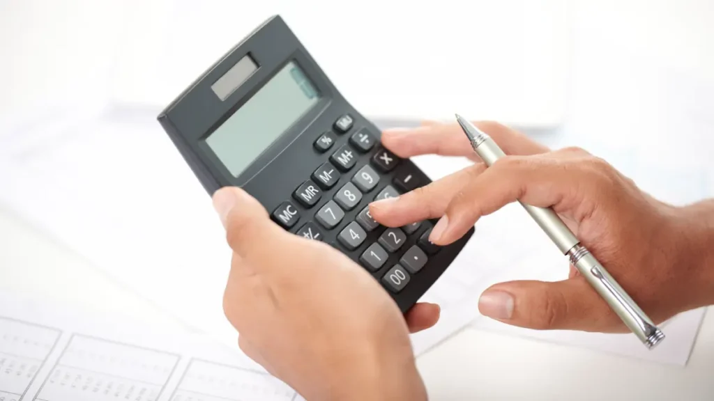 Medo de dívidas. Mãos segurando calculadora e caneta.