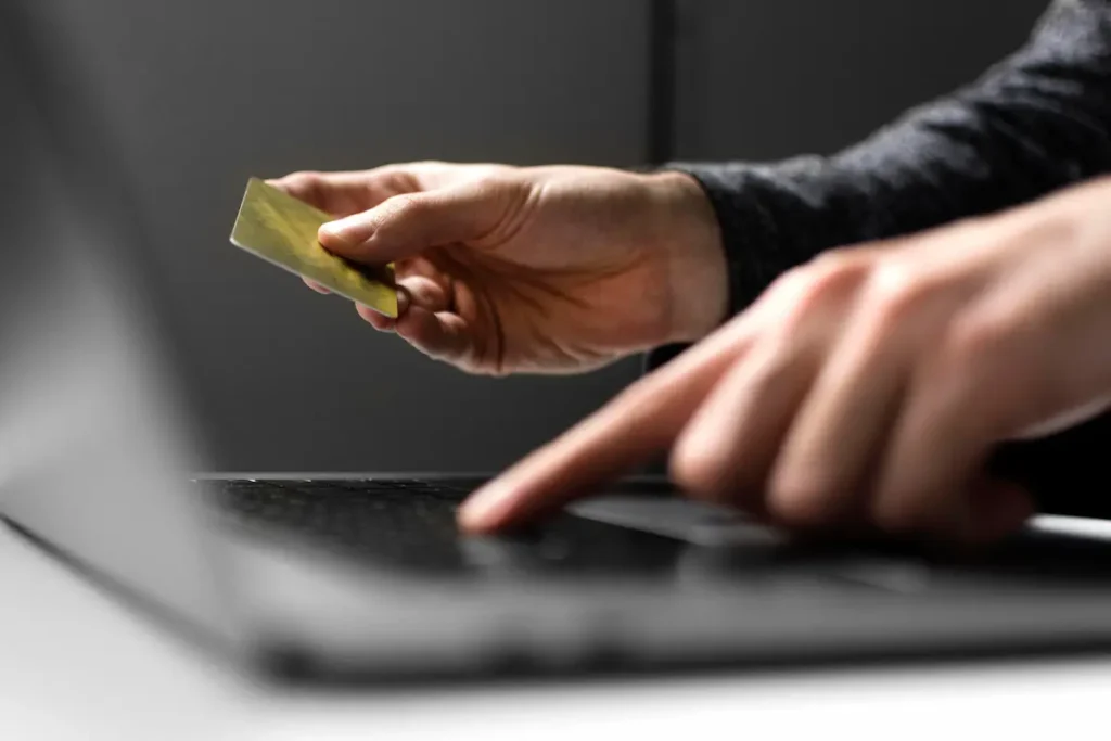 Consumidor realizando compra online com cartão de crédito em notebook durante oferta digital.